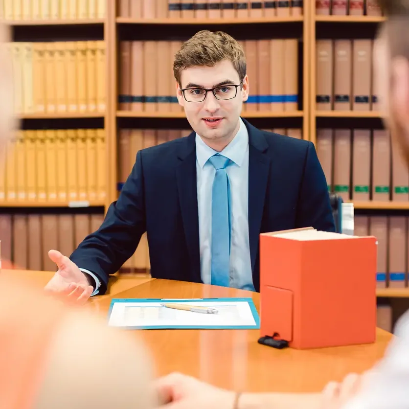 Legal studies professional meeting with clients in an office, reviewing documents and providing guidance